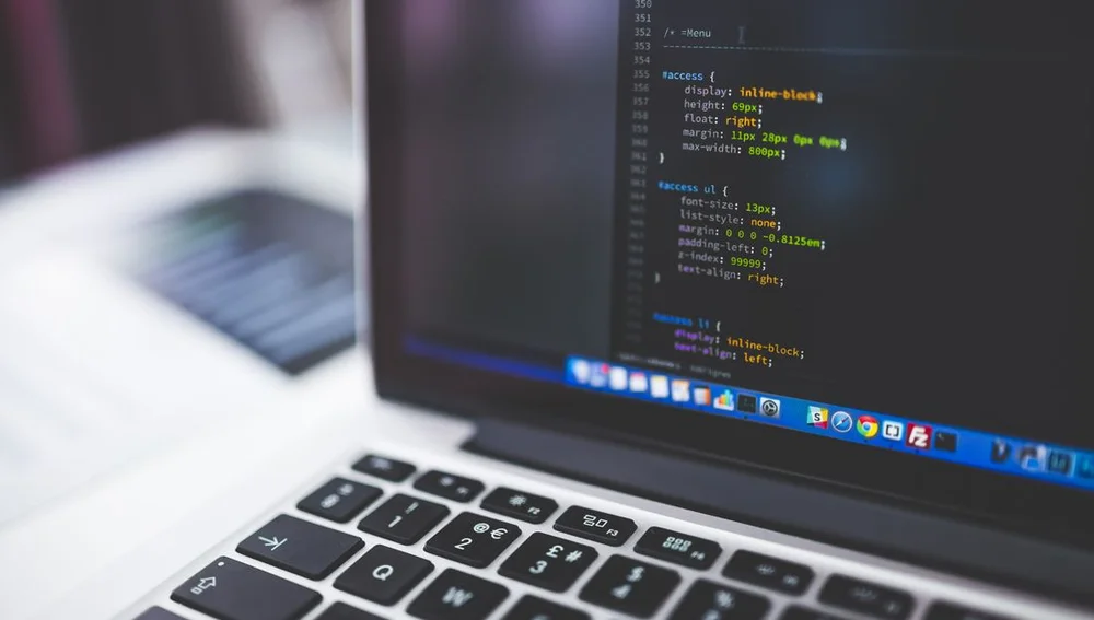 Laptop layar coding website — representasi jasa website Surabaya profesional