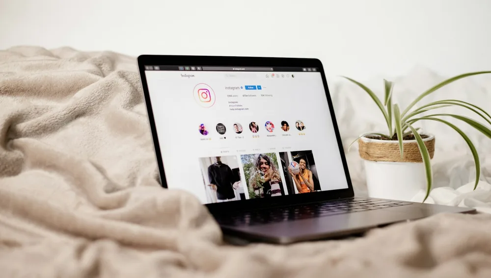 Laptop menampilkan feed Instagram, layar social media untuk pekerjaan digital marketer