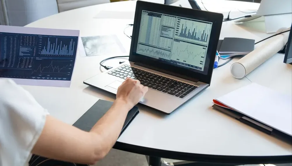 Laptop dengan dashboard analitik di meja kerja, gambaran analitik properti dan pengukuran lead